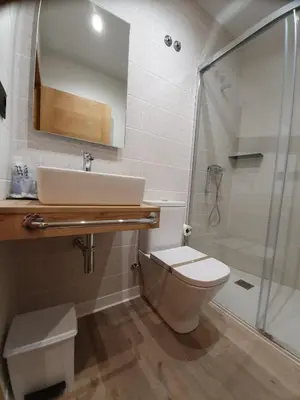 a bathroom with a toilet and a sink and a shower at Albergue Casa Cuartel in Fonsagrada