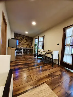 a living room with a table and chairs and a tv at Albergue Casa Cuartel in Fonsagrada