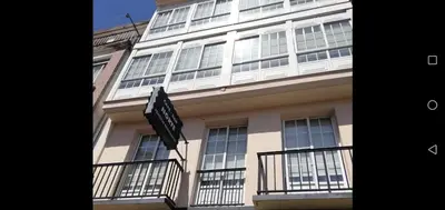a building with a flag hanging off the side of it at Hospedaje Norte in Puentedeume