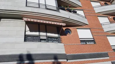 a person walking past a building with windows at Piso Tranquilo Ponferrada in Ponferrada