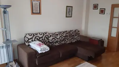 a brown couch with a pillow on it in a living room at Piso Tranquilo Ponferrada in Ponferrada
