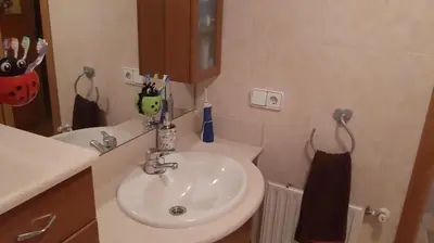 a bathroom with a sink and a toilet and a mirror at Piso Tranquilo Ponferrada in Ponferrada