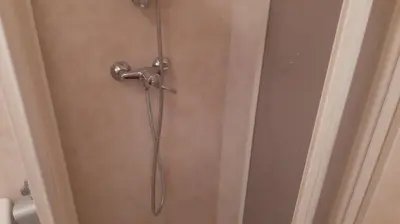 a shower head on a door in a bathroom at Piso Tranquilo Ponferrada in Ponferrada