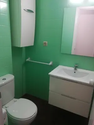 a green bathroom with a toilet and a sink at PISO XUNQUEIRA in Viveiro