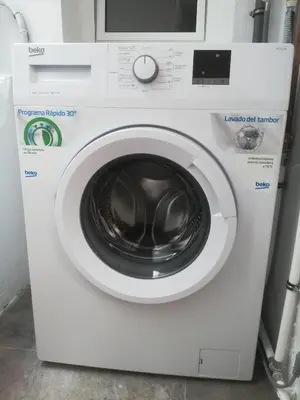 a washing machine with a microwave on top of it at PISO XUNQUEIRA in Viveiro