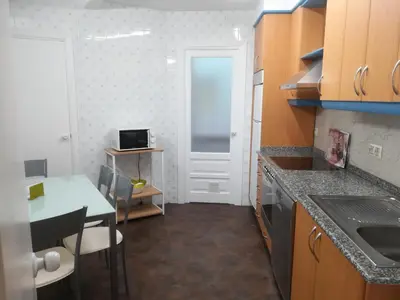a small kitchen with a table and a door at PISO XUNQUEIRA in Viveiro