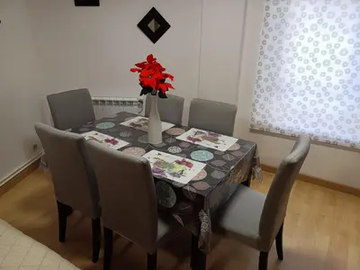 a dining room table with a vase of flowers on it at PISO XUNQUEIRA in Viveiro