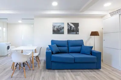 a living room with a blue couch and a table at MIRADOR DE LA MURALLA in Betanzos