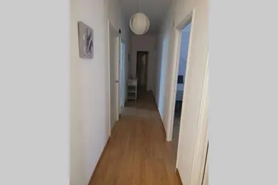 a hallway with white walls and a wooden floor at Apartamento Lalín Centro ll in Lalín