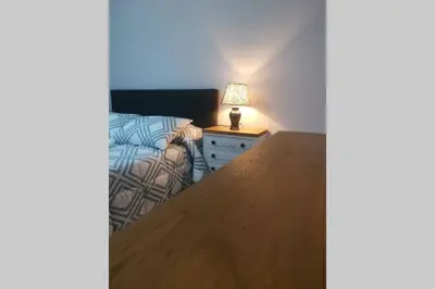 a bedroom with a bed and a lamp on a night stand at Apartamento Lalín Centro ll in Lalín