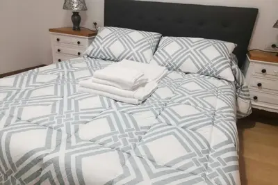 a bed with white sheets and pillows in a bedroom at Apartamento Lalín Centro ll in Lalín