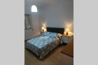 a small bedroom with a bed and two lamps at Apartamento Lalín Centro ll in Lalín