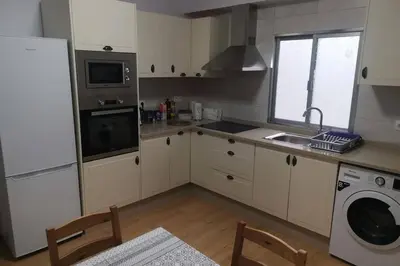 a kitchen with white cabinets and a sink and a dishwasher at Apartamento Lalín Centro ll in Lalín
