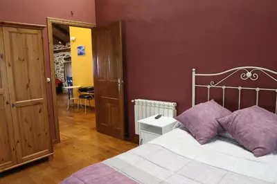 a bedroom with a bed with purple pillows at Casa Rural Madreselva in Navelgas