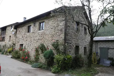 an old stone building with flowers in front of it at Casa Rural Madreselva in Navelgas