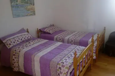 two beds in a room with purple comforters at CASA NIDES in Doade