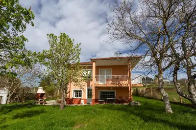 a house with a balcony and a yard at CASA NIDES in Doade