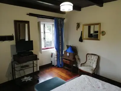 a living room with a television and a chair at Casa Oute in Sobrada