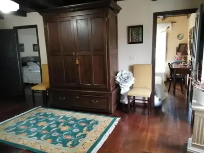 a living room with a large wooden cabinet and a rug at Casa Oute in Sobrada