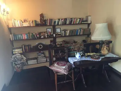 a room with a table with a lamp and a book shelf at Casa Oute in Sobrada