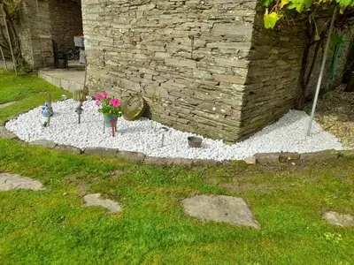 a garden with flowers and a stone wall at Casa Oute in Sobrada