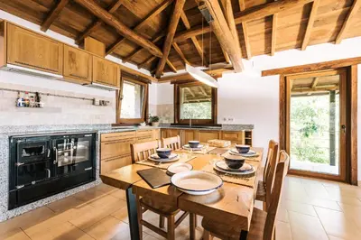 a large kitchen with a wooden table and chairs at Casa de lujo en la Ribeira Sacra in Acova