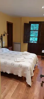 a bedroom with a white bed with towels on it at CASA MUNIELLOS in Cangas del Narcea