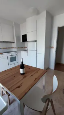a bottle of wine sitting on a wooden table in a kitchen at Morgon House in Molinaseca