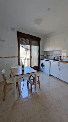 a kitchen with a table and chairs in a room at Morgon House in Molinaseca
