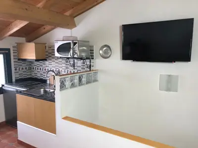 a kitchen with a sink and a tv on the wall at Casa da Ponte in Monforte de Lemos