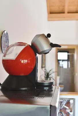 a red and black mixer sitting on top of a microwave at Casa da Ponte in Monforte de Lemos