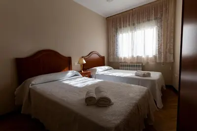 a hotel room with two beds with hats on them at Playa de Llas in Foz