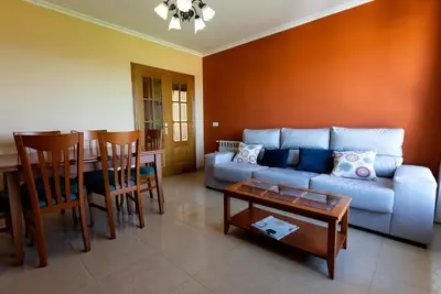 a living room with a couch and a table at Playa de Llas in Foz