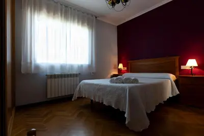 a bedroom with a white bed and a window at Playa de Llas in Foz
