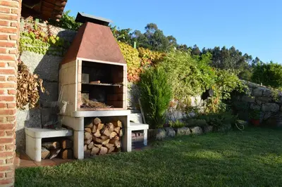 a outdoor oven with a pile of fire wood at Airiños de Mondariz in Mondariz