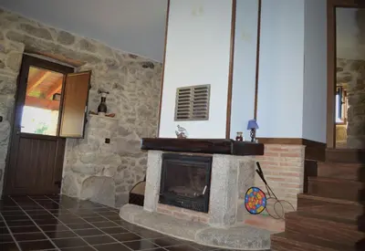 a stone fireplace in a room with a staircase at Airiños de Mondariz in Mondariz