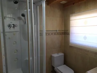 a bathroom with a white toilet and a shower at Casas de madera 