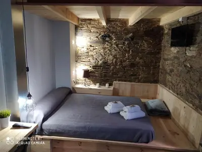 a bedroom with a bed and a stone wall at Albergue Atrio in Tríacastela