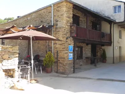 an umbrella sitting outside of a building with a patio at Albergue Atrio in Tríacastela