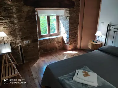 a bedroom with a bed and a window at Albergue Atrio in Tríacastela