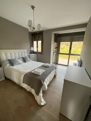 a bedroom with a large bed and a table at Casa nueva con jardín y wifi en Ribeira Sacra in Castrelo