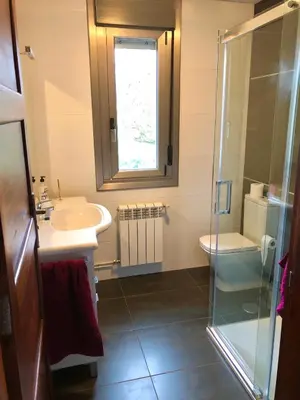a bathroom with a sink and a toilet and a window at Casa nueva con jardín y wifi en Ribeira Sacra in Castrelo