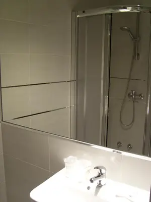 a bathroom with a sink and a large mirror at PR Tambre in Santiago de Compostela