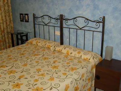 a bedroom with a bed with a floral bedspread at PR Tambre in Santiago de Compostela