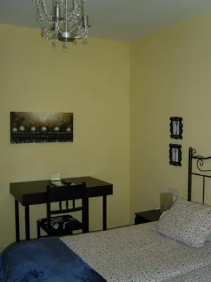 a bedroom with a table and a bed and a chandelier at PR Tambre in Santiago de Compostela