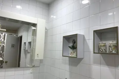 a bathroom with white tiled walls and a mirror at cuartin del camino in Ponferrada