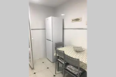a kitchen with a table and a refrigerator at cuartin del camino in Ponferrada