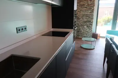 a kitchen with black and white counters and a table at A Palleira de Lola in Lugo