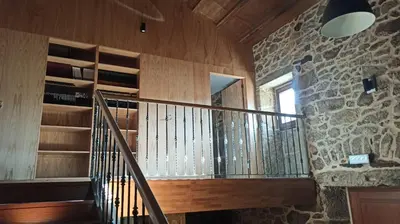 a staircase in a room with a stone wall at Villageermis - Casa Rural in Moraña