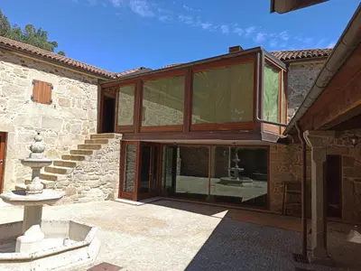 an external view of a house with glass doors at Villageermis - Casa Rural in Moraña